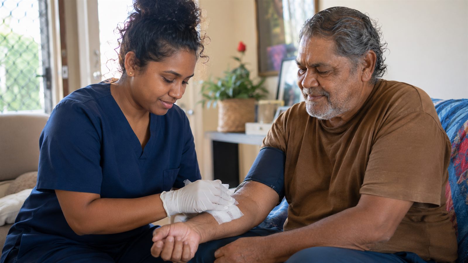 A community nurse providing gentle care to a calm patient at home